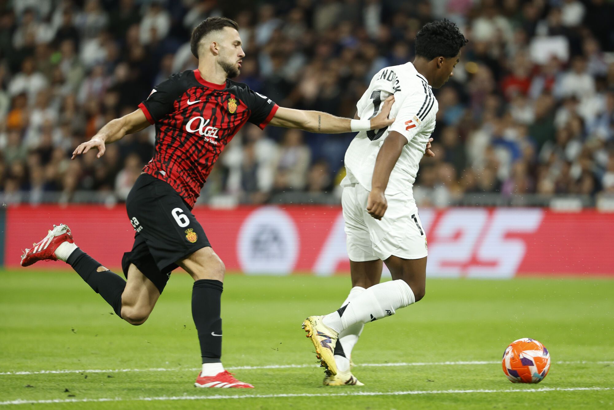 MADRID, 14/05/2025.- El delantero brasileño del Real Madrid Endrick Felipe (d) se escapa de José Copete, del Mallorca, durante el partido de la jornada 36 de LaLiga de fútbol que Real Madrid y RCD Mallorca disputan este miércoles en el estadio Santiago Bernabéu. EFE/Chema Moya