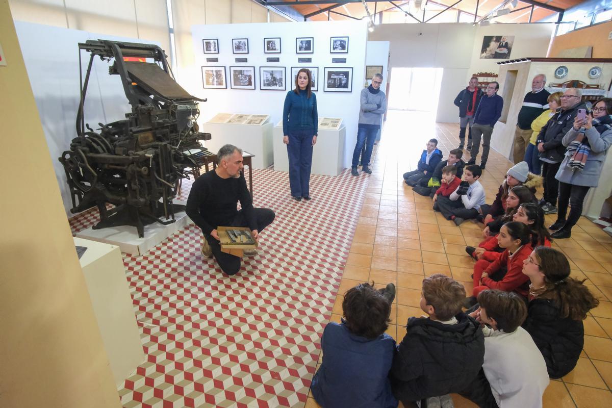 Un grupo de escolares escucha atentamente las explicaciones del comisario de la exposición.