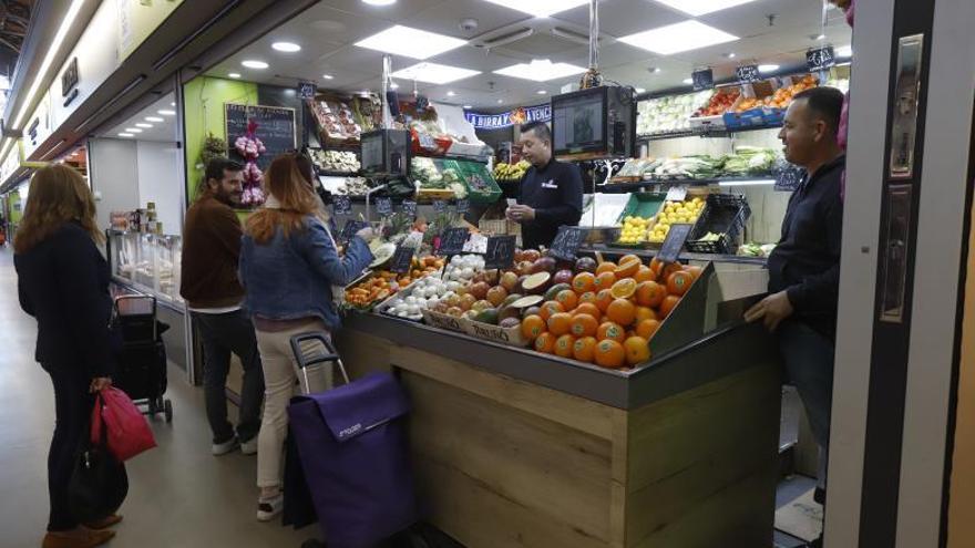 Una frutería del Mercado Central de Zaragoza con varios clientes, el pasado lunes. | FIRMA DE FOTO