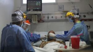 Personal médico atienden a enfermo de COVID-19 en Argentina.