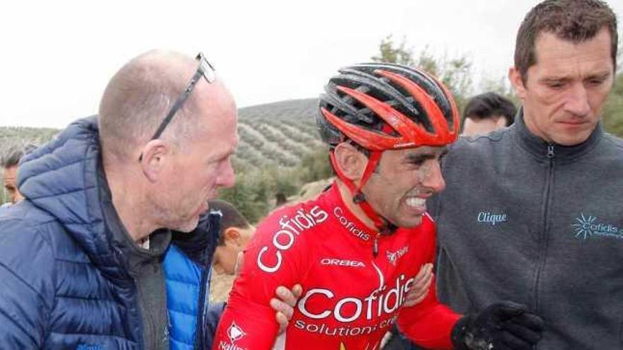 Dani Navarro, dolorido tras la caída, es acompañado al coche del equipo.