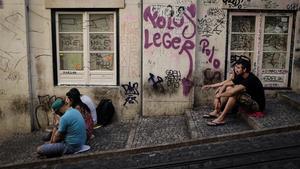 Unos turistas esperan la llegada del tranvía en Lisboa. 