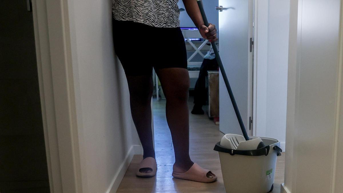 Una empleada doméstica friega el suelo.