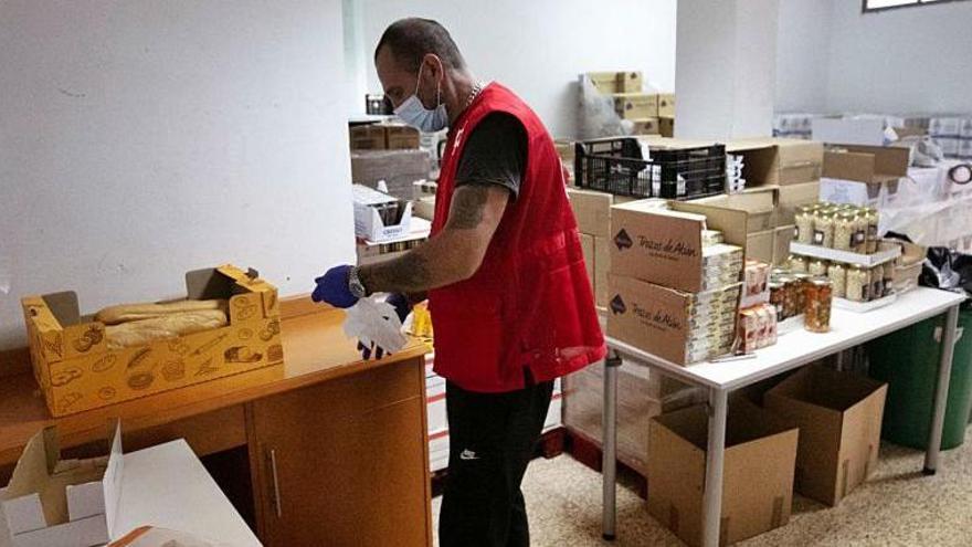 Un voluntario de Cruz Roja prepara los alimentos que recoge un usuario, el pasado martes en la sede de la entidad en Ibiza.