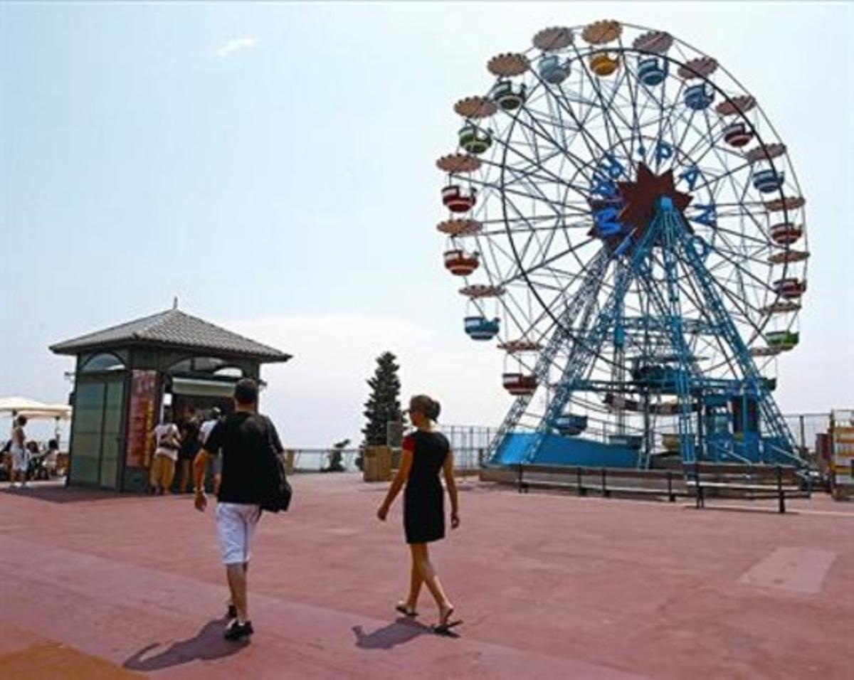 Una parella de turistes passeja per la cota 500 del Tibidabo, oberta des de dilluns, ahir a la tarda. Una parella de turistes passeja per la cota 500 del Tibidabo, oberta des de dilluns, ahir a la tarda.