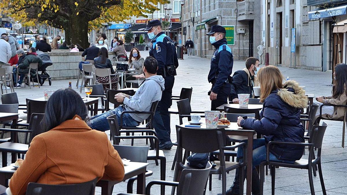 Dos agentes de la Policía Local de Salceda controlando medidas sanitarias en una de las plazas. |   // D.P.