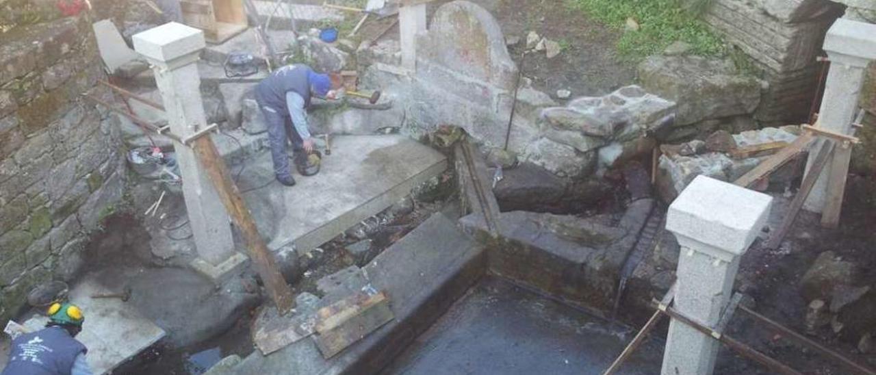 Alumnos del taller realizan obras de reparación en el lavadero de Fonte da Tella. // Santos Álvarez