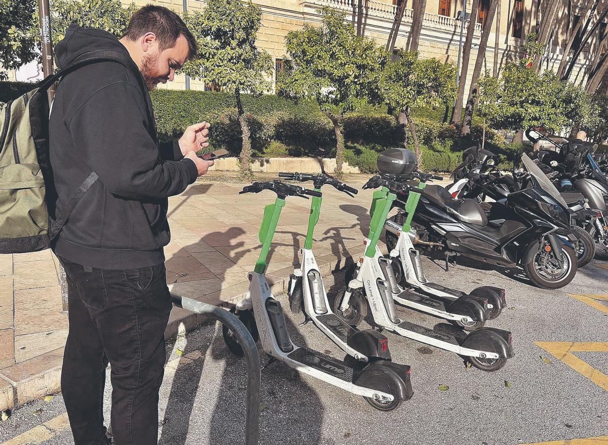 Un usuario recoge un patinete de alquiler.