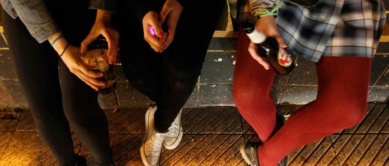 Tres chicas, en el exterior de un bar de copas de la ciudad.