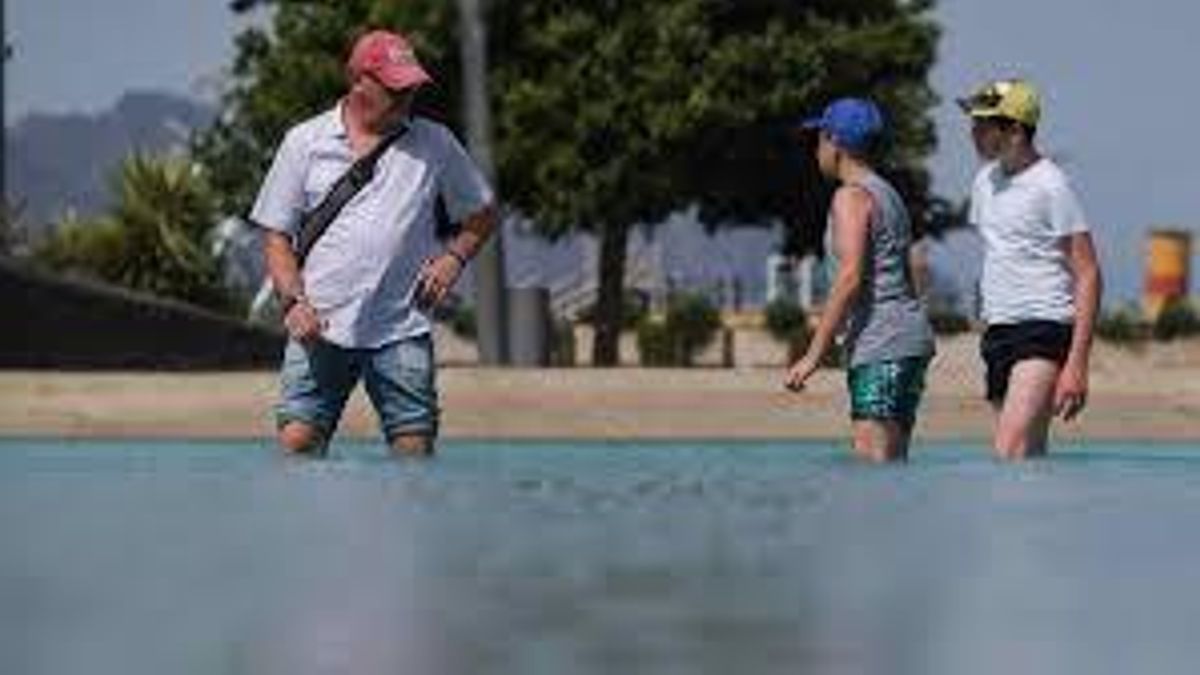 Varias personas huyen del calor en el lago de la Plaza España, Santa Cruz.