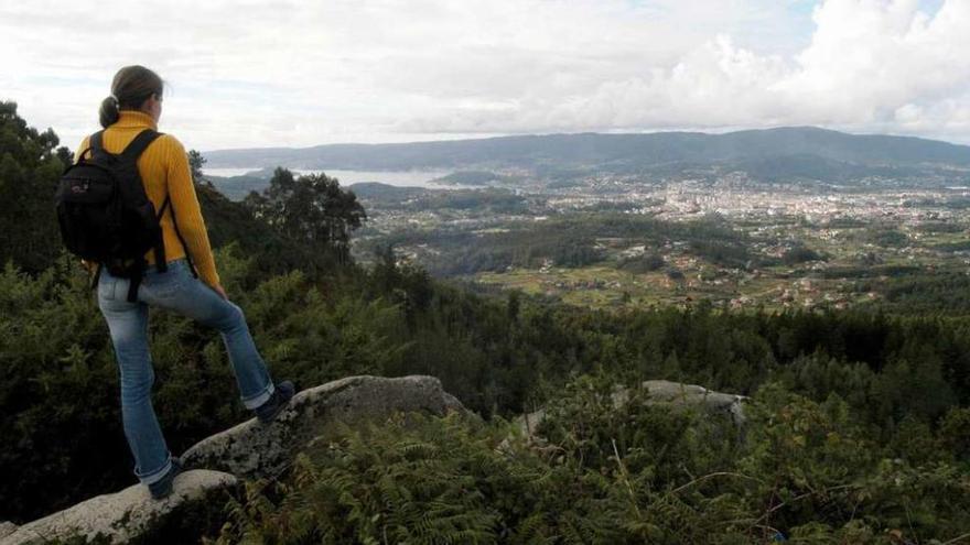 Una senderista observa la ciudad de Pontevedra desde el monte de A Fracha. // Gustavo Santos
