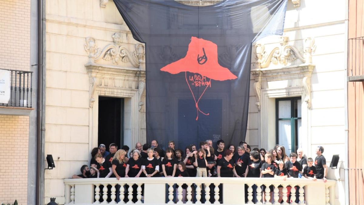 Samarreta que s'ha desplegat al balcó de l'Ajuntament de Berga i berguedans de totes les edats que han participat en la promoció de la nova peça patumaire