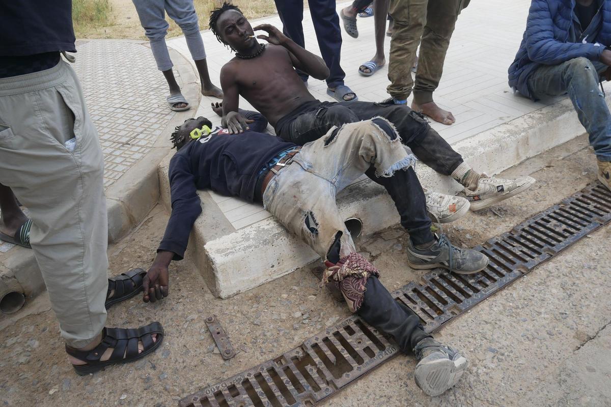 GRAF6934. MELILLA, 24/06/2022.- Varias decenas de inmigrantes han entrado este viernes en Melilla tras romper la puerta de acceso al paso fronterizo de Barrio Chino y saltar por encima de su tejado que separa la ciudad autónoma de Marruecos. EFE/ Paqui Sánchez