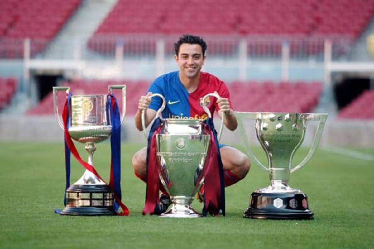 Xavi, amb tres dels trofeus del Barça de la temporada 2008-2009.