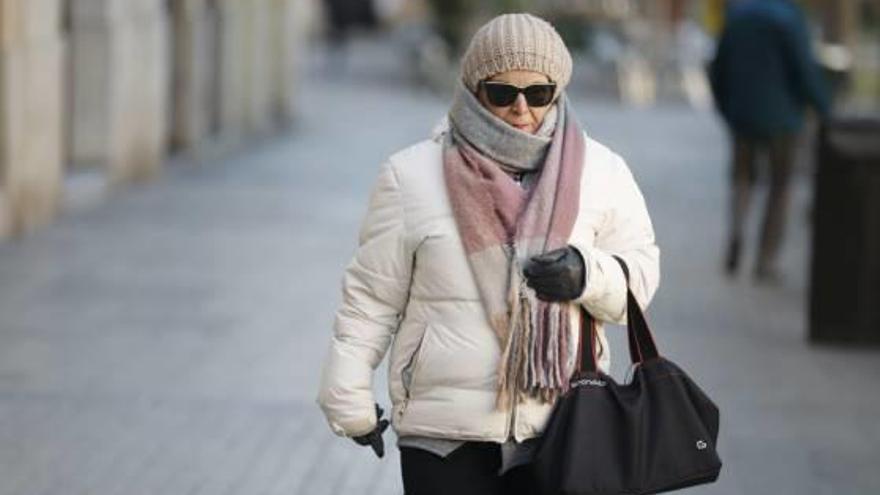 Una mujer se resguarda del frío, en la mañana de ayer, en el centro de València.