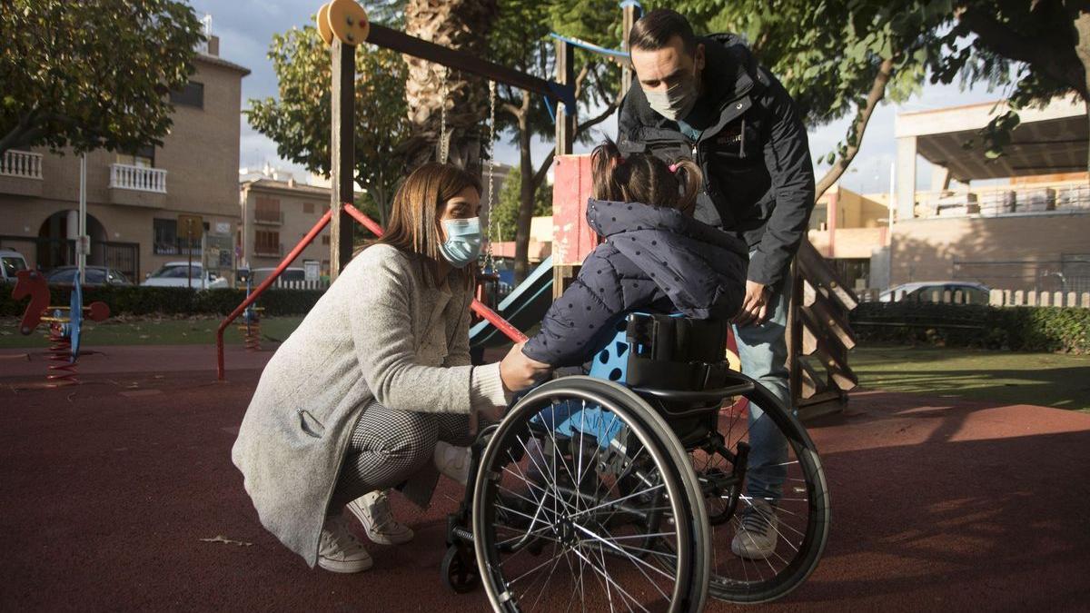 La Carmen, junt amb els seus pares en un parc infantil