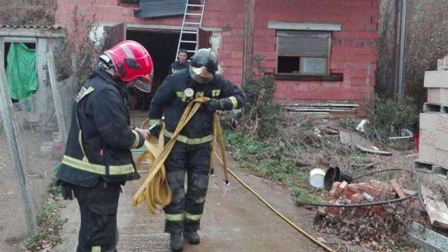 Los bomberos proceden a recoger las mangueras tras la intervención.