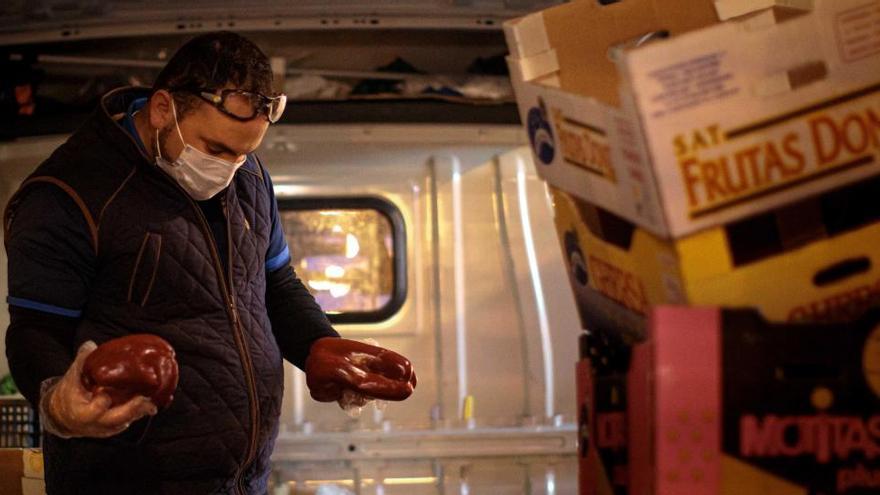 Un autónomo organiza pedidos de fruta en su furgoneta.