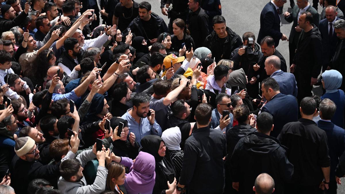 El presidente turco, Recep Tayyip Erdogan, y su esposa, Emine Erdogan, rodeados por la multitud cuando salen del colegio electoral después de votar en las elecciones presidenciales y parlamentarias, en Estambul, Turquía.