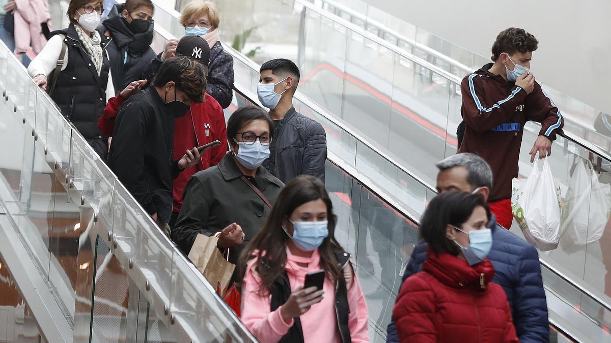 Clientes con mascarilla en un centro comercial.