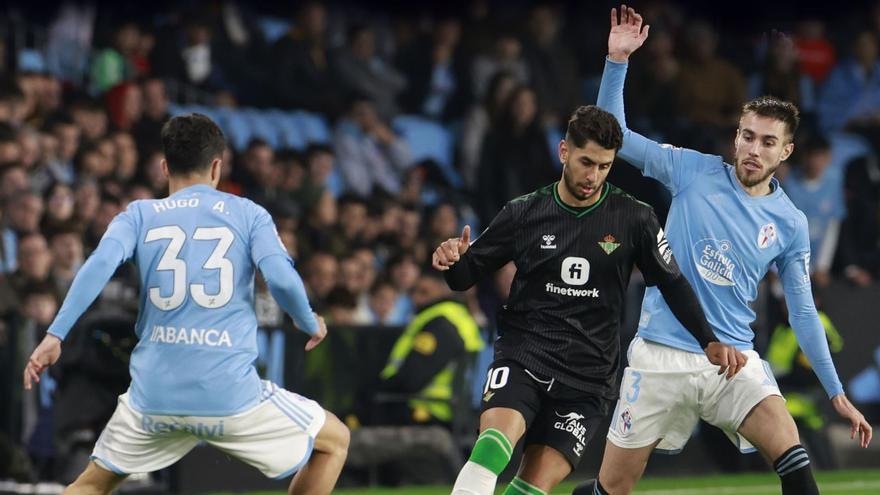 Hugo Álvarez, de espaldas, y
Mingueza marcan a Ayoze durante
la última visita del Betis a
Balaídos.  | // RICARDO GROBAS