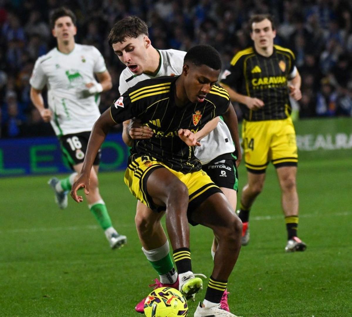 Álex Gomes protege el balón ante Salinas en el duelo ante el Racing.