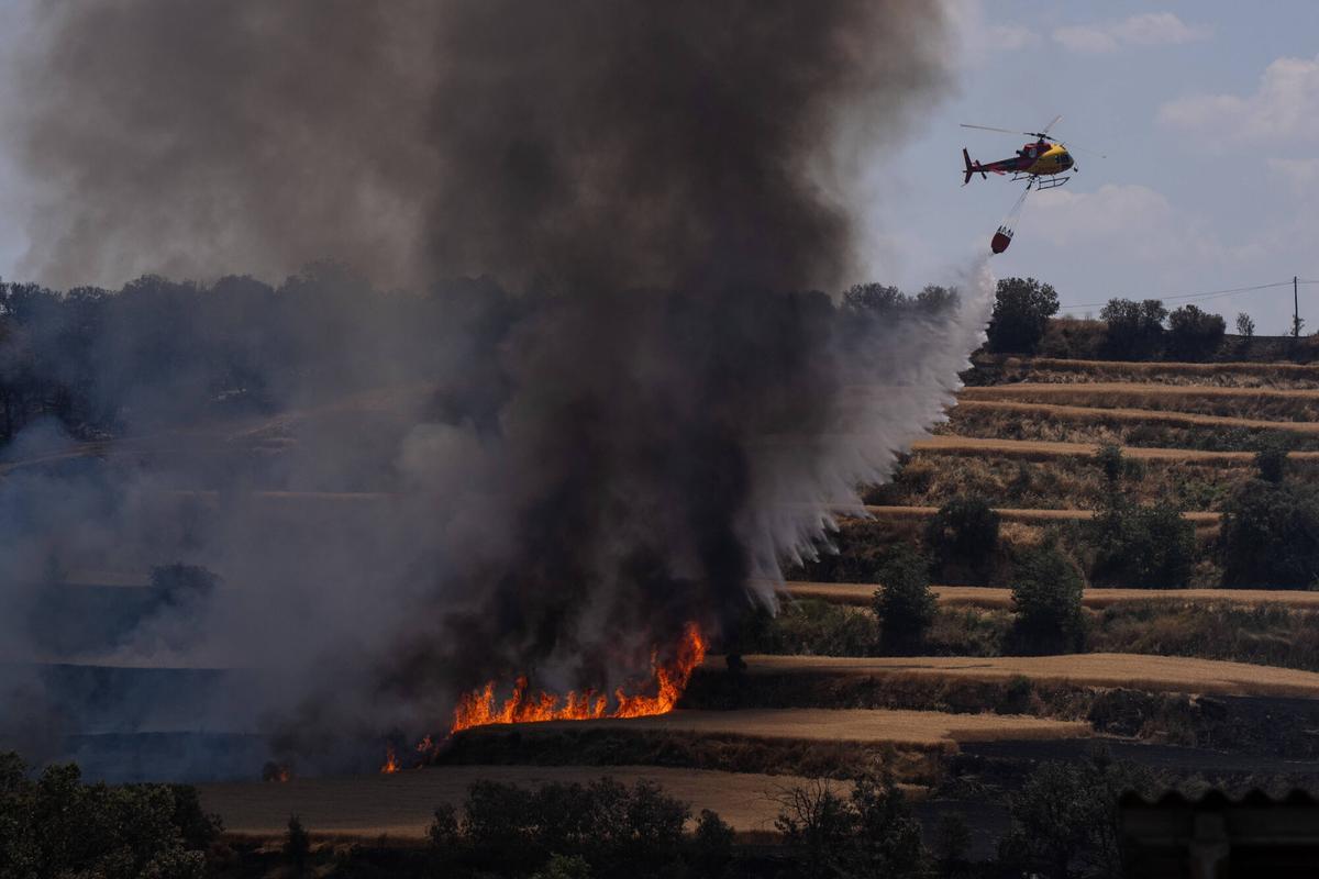 Helicópteros de bomberos asisten en la extinción de los focos que reaparecen en Guardiola, Lleida, este 2 de julio de 2025. Un día después del incendio que, según las investigaciones, se originó por una segadora en Torrefeta, las labores de control continúan.