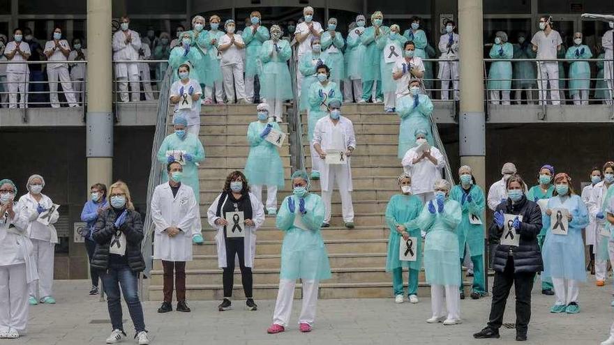 Sanitarios aplauden tras el minuto de silencio en la entrada del Hospital Doctor Peset, en Valencia, por la técnica de enfermería fallecida por coronavirus. // Rober Solsona / Europa Press