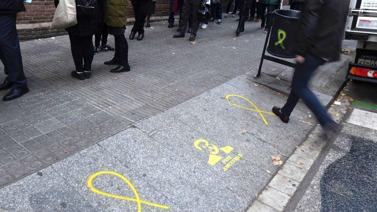 Lazos amarillo y una pintada en apoyo a Oriol Junqueras en la acera frente al colegio La Sedeta de Barcelona.