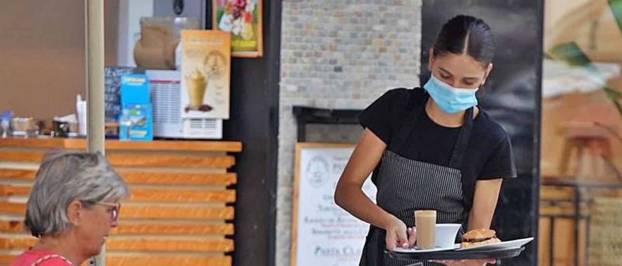 Una camarera sirve un cortado en una terraza de la capital grancanaria. | | JC CASTRO