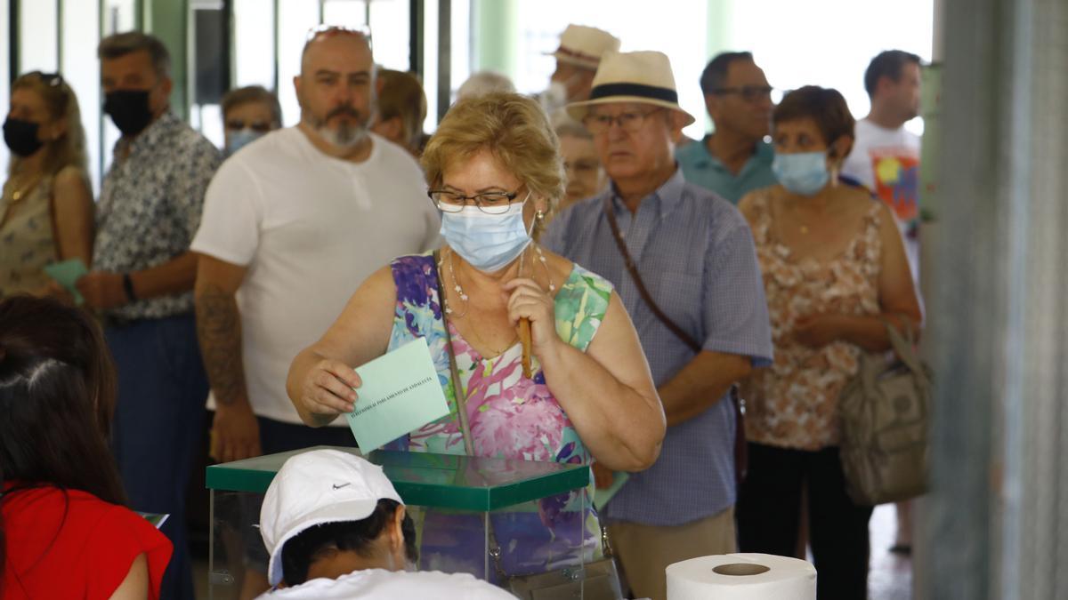 Colas de personas esperan para introducir en la urna su papeleta de voto en un colegio de Córdoba