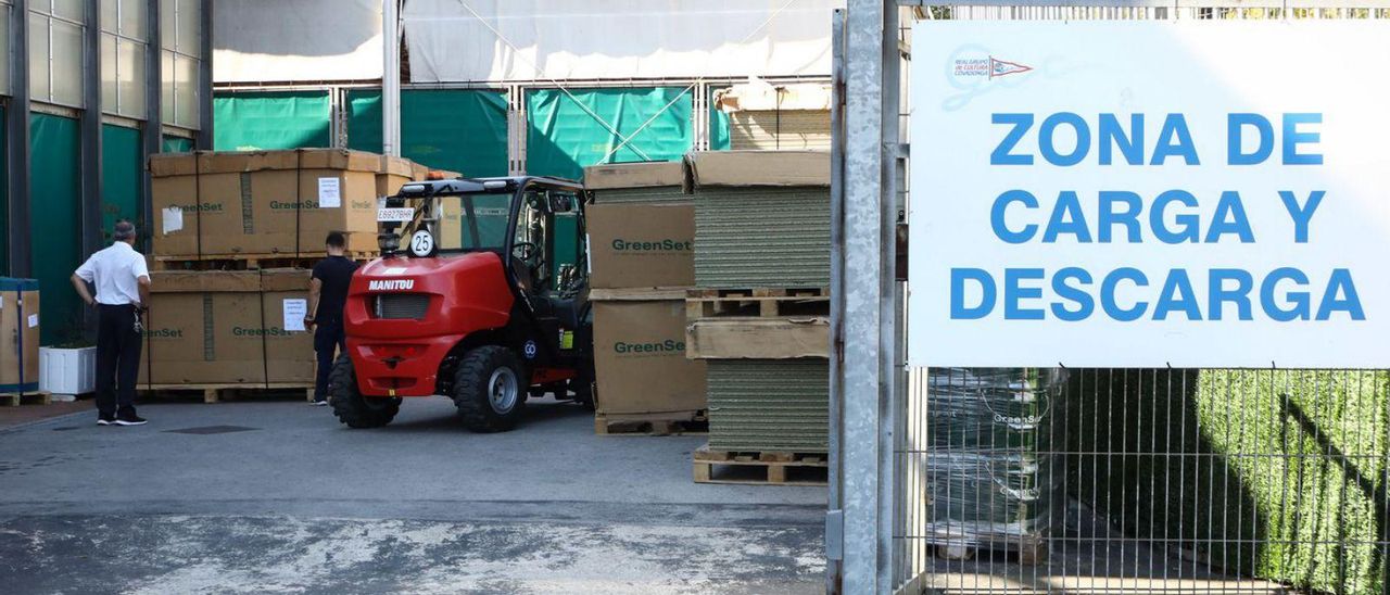 La llegada de materiales para las pistas de entrenamiento del Gijón Open en el Grupo, ayer. | Juan Plaza