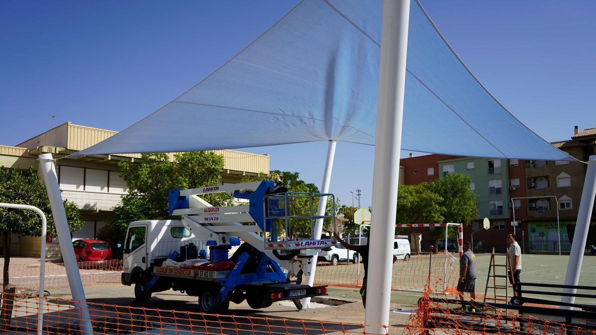 Instalación de un toldo en un colegio municipal en el marco del plan sombra.