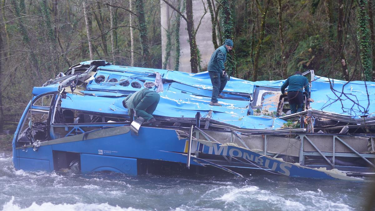 Agentes de la Guardia Civil valoran las posibilidades de anclaje del autocar para proceder a su rescate de las augas del Lérez.