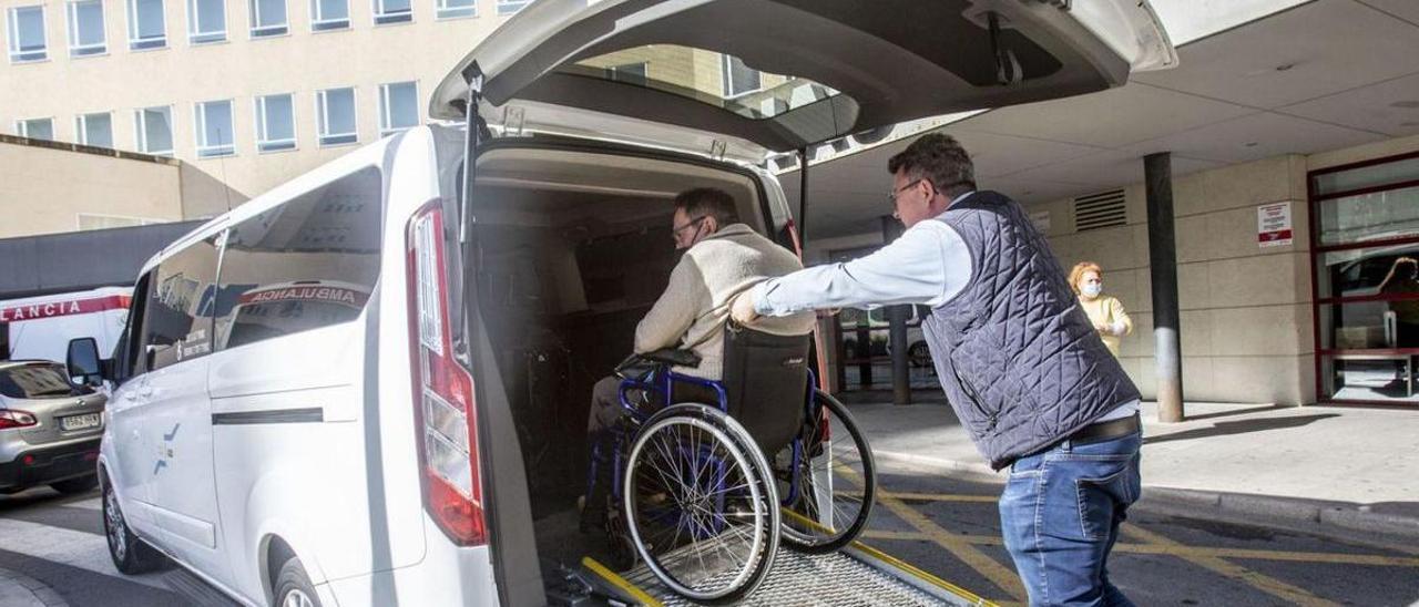 Foto de archivo de un hombre en silla de ruedas entrando en un taxi adaptado a personas con movilidad reducida.