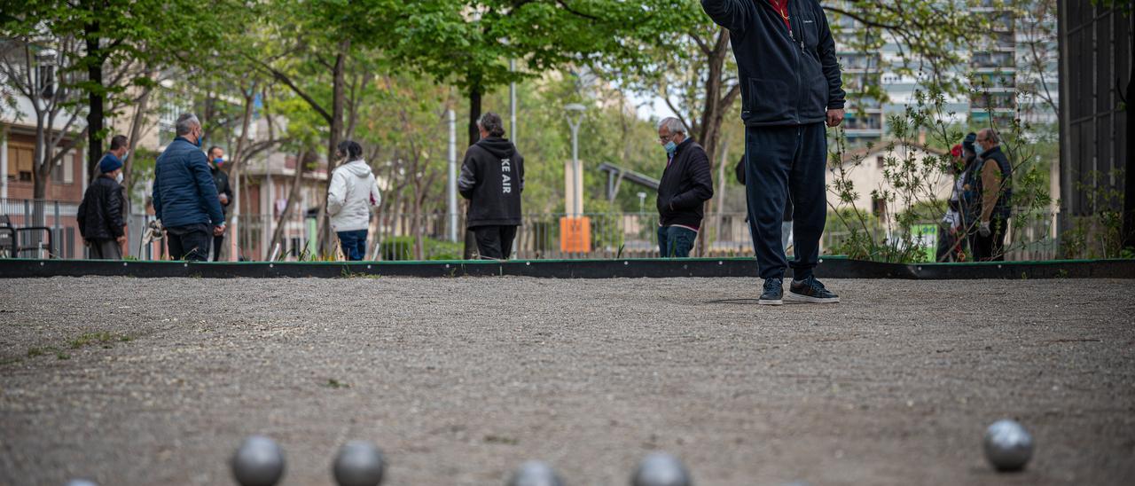 Un grupo de jubilados juegan a la petanca en un parque.