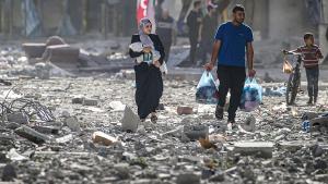 Una familia palestina camina entre los escombros después de los ataques aéreos israelís en el barrio de Tel al-Hawa, en la ciudad de Gaza.