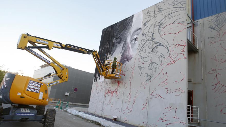 Lula Goce pinta un mural en la fachada de Bellas Artes de la UMU