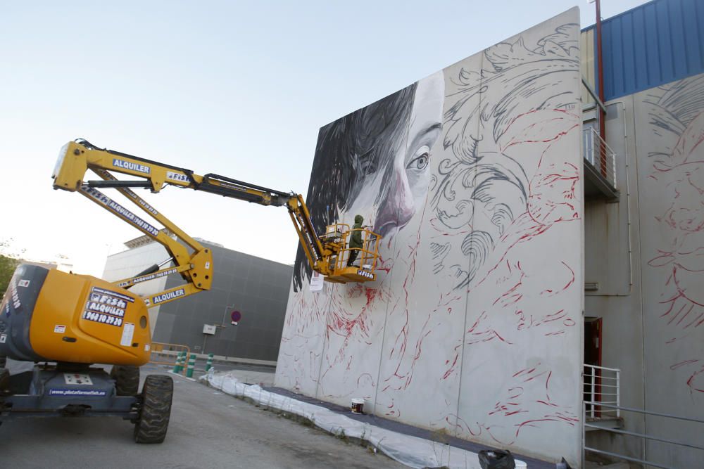 Lula Goce pinta un mural en la fachada de Bellas Artes de la UMU