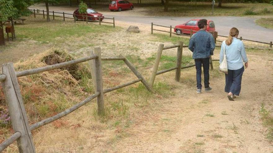 Dos visitantes abandonan el castro, que tiene parte de las vallas tumbadas. // Noé Parga