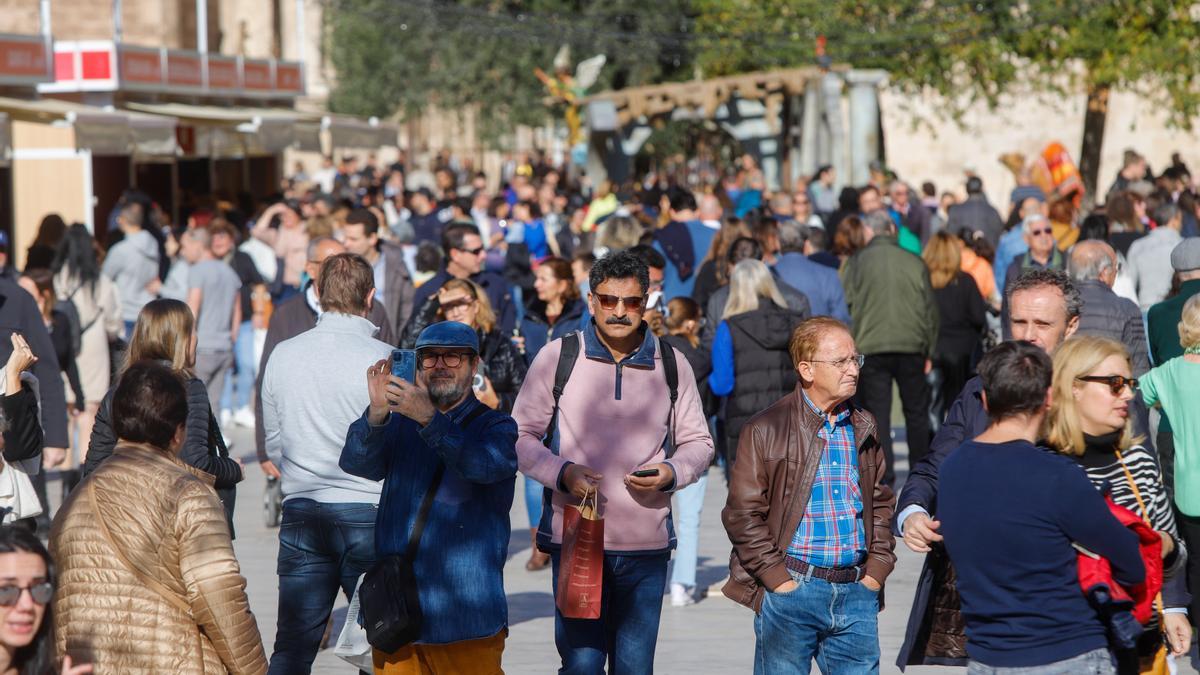 Personas en la plaza de la Virgen en el ambiente prenavideño.