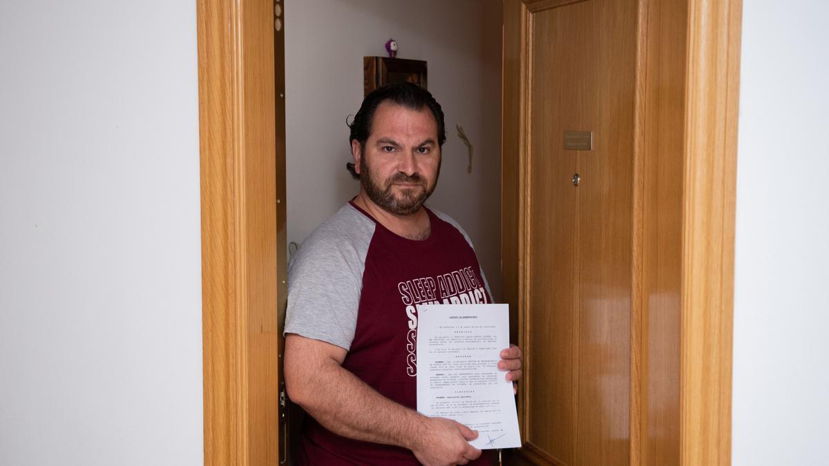 Uno de los vecinos que reside en la finca de Almassora, con una copia del contrato que mantiene con una inmobiliaria.