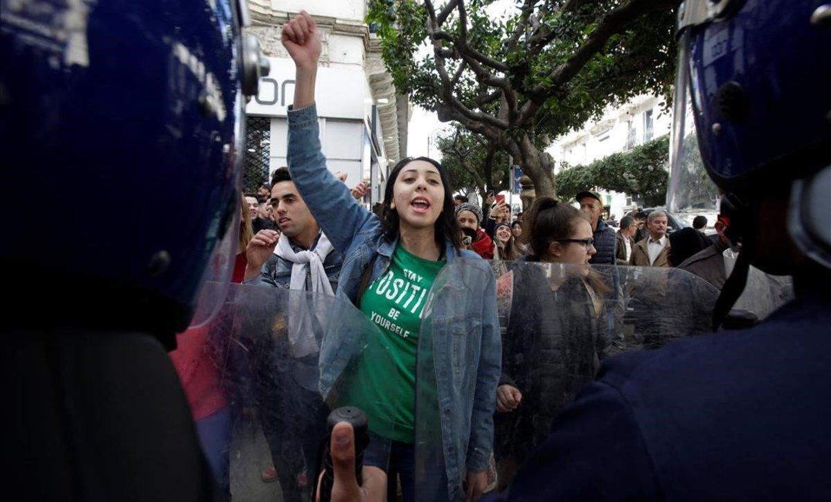 Unos estudiantes protestan en las calles de Argel contra Buteflika ante la vigilancia del amplio dispositivo policial, este martes.