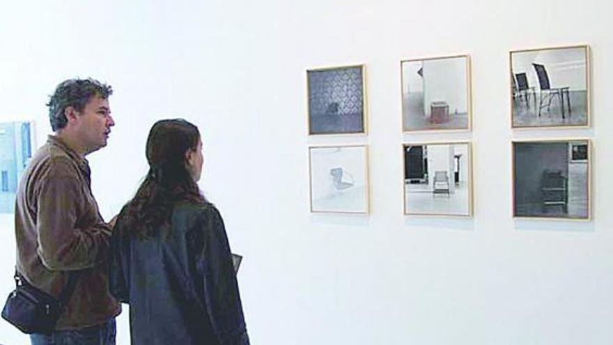 Dos visitantes contemplan fotografías de «Colección permanente», de José Ferrero, en Oporto.