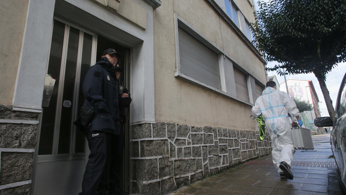 Un agente de Policía Nacional en la puerta de la vivienda donde se halló a la mujer