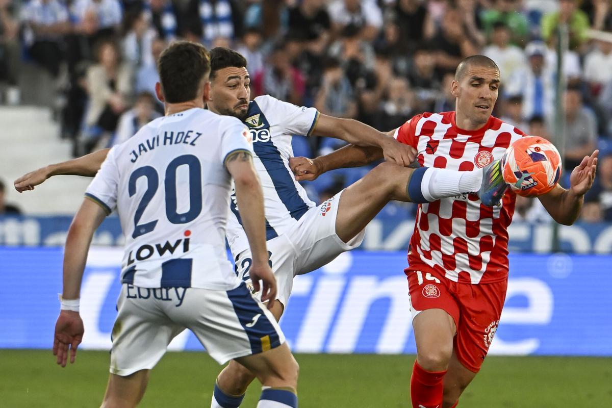LEGANÉS (MADRID), 24/04/2025.- El delantero del Leganés Munir El Haddadi (i) disputa un balón ante Oriol Romeu del Girona, durante el partido de la jornada 33 de LaLiga EA Sports que CD Leganés y Girona FC disputan este jueves en el estadio de Butarque. EFE/Fernando Villar