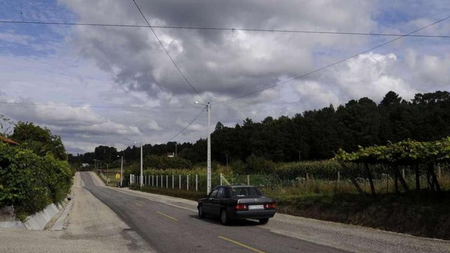 La senda peatonal discurrirá por el tramo sin aceras entre Berres y Riobó. Abajo, obras de hormigonado de las aceras, ayer, en Moreira.