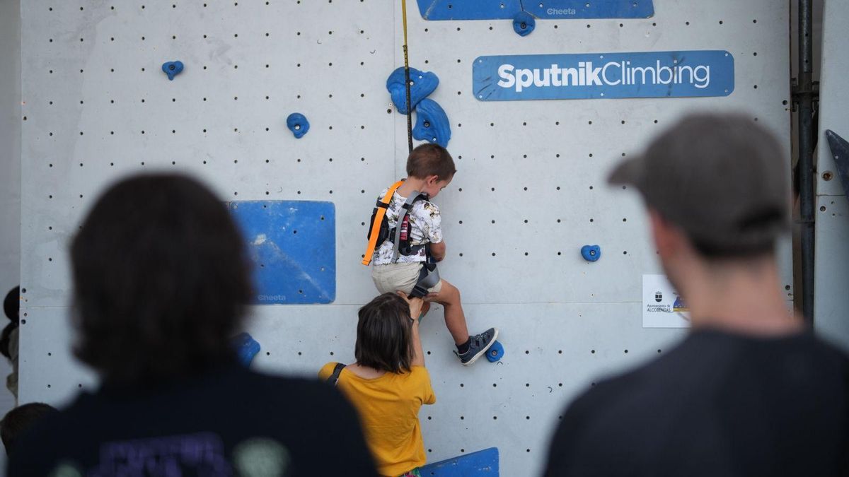 Un niño escala ayudado por su madre en el muro popular de búlder esta sábado a mediodía.