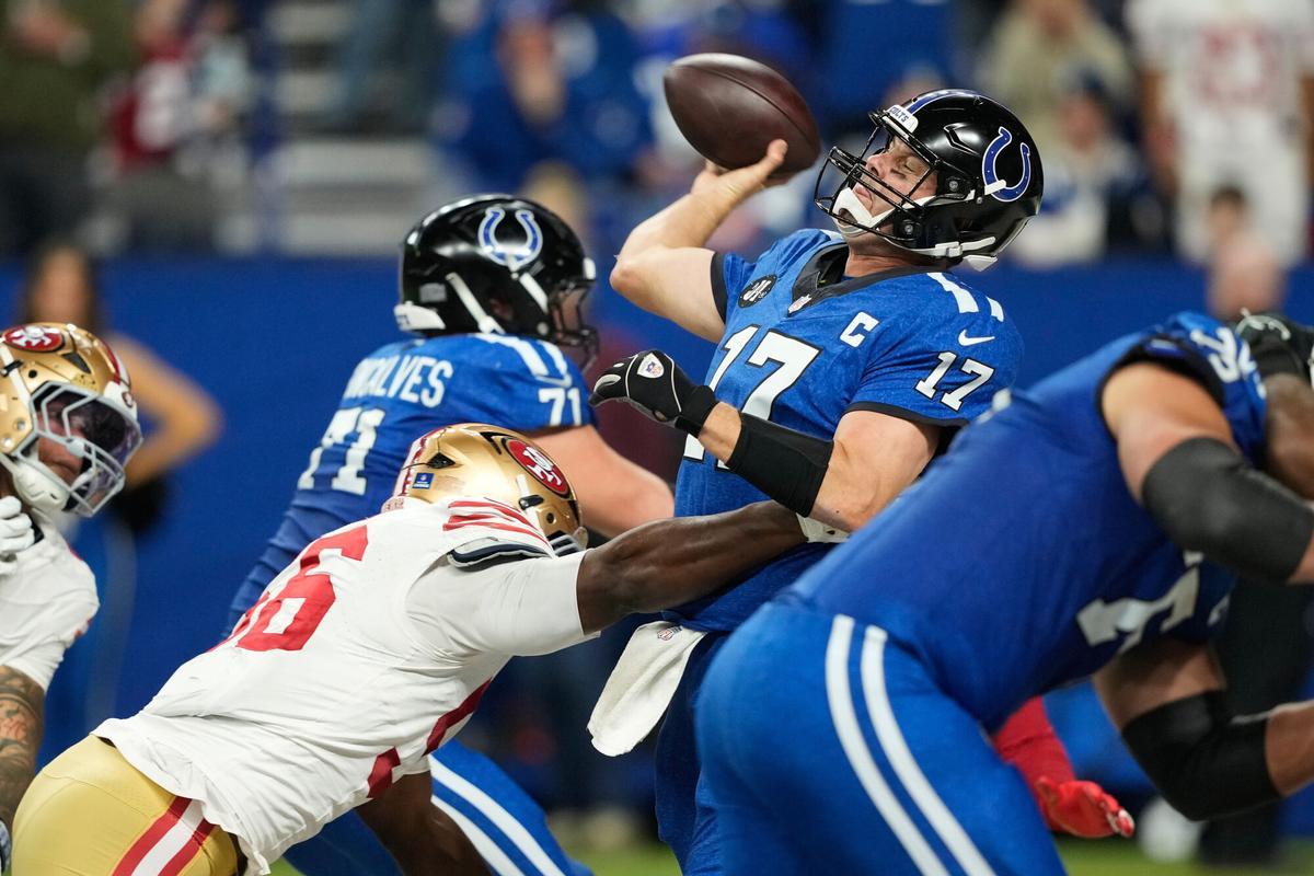 Indianapolis Colts quarterback Philip Rivers (17) passes while pressured by San Francisco 49ers defensive end Clelin Ferrell during the second half of an NFL football game, Monday, Dec. 22, 2025, in Indianapolis. (AP Photo/Carolyn Kaster)