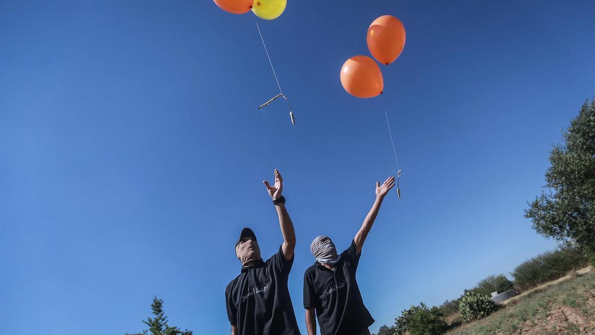 Un grupo de palestinos lanzan globos incendiarios desde Gaza con destino a Israel.